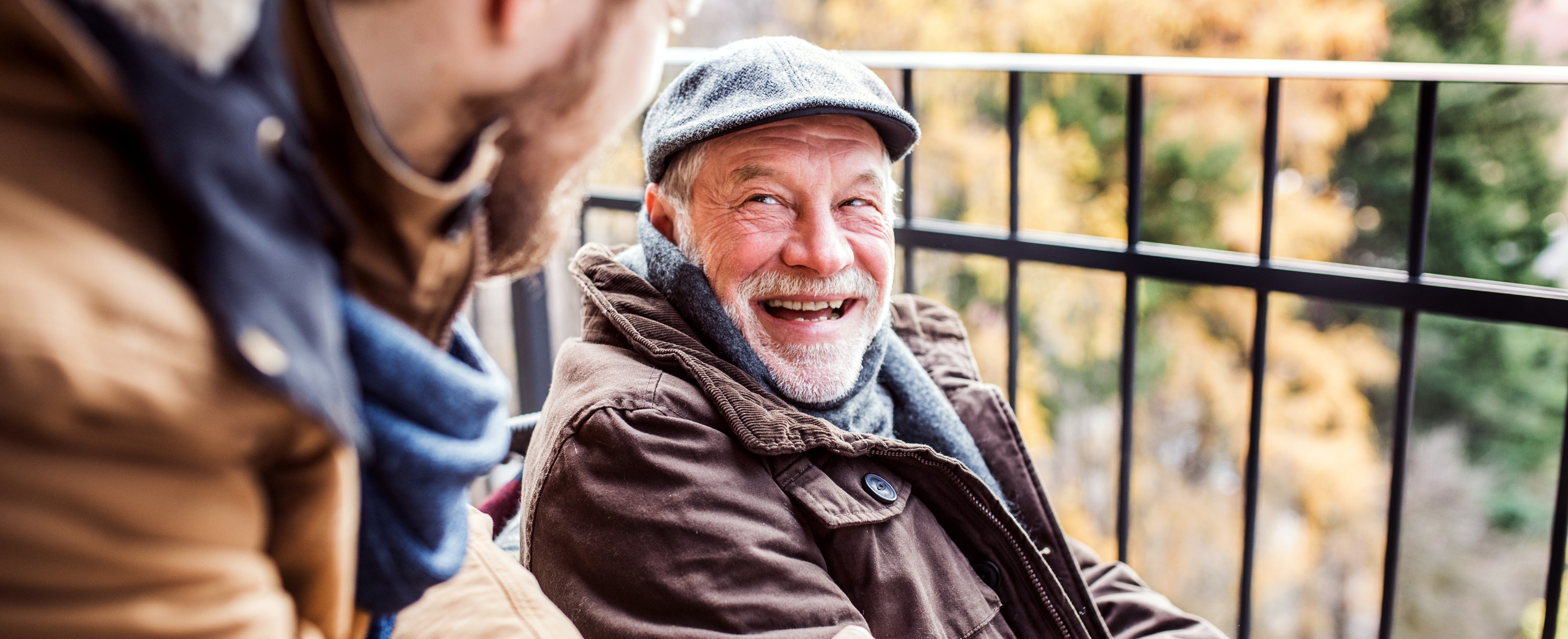 Older man and younger man smiling at each other