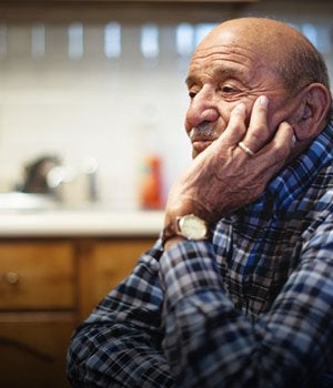 Old man sat at a table. Brain health.