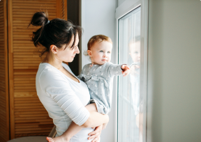 Mother and daughter looking out of window