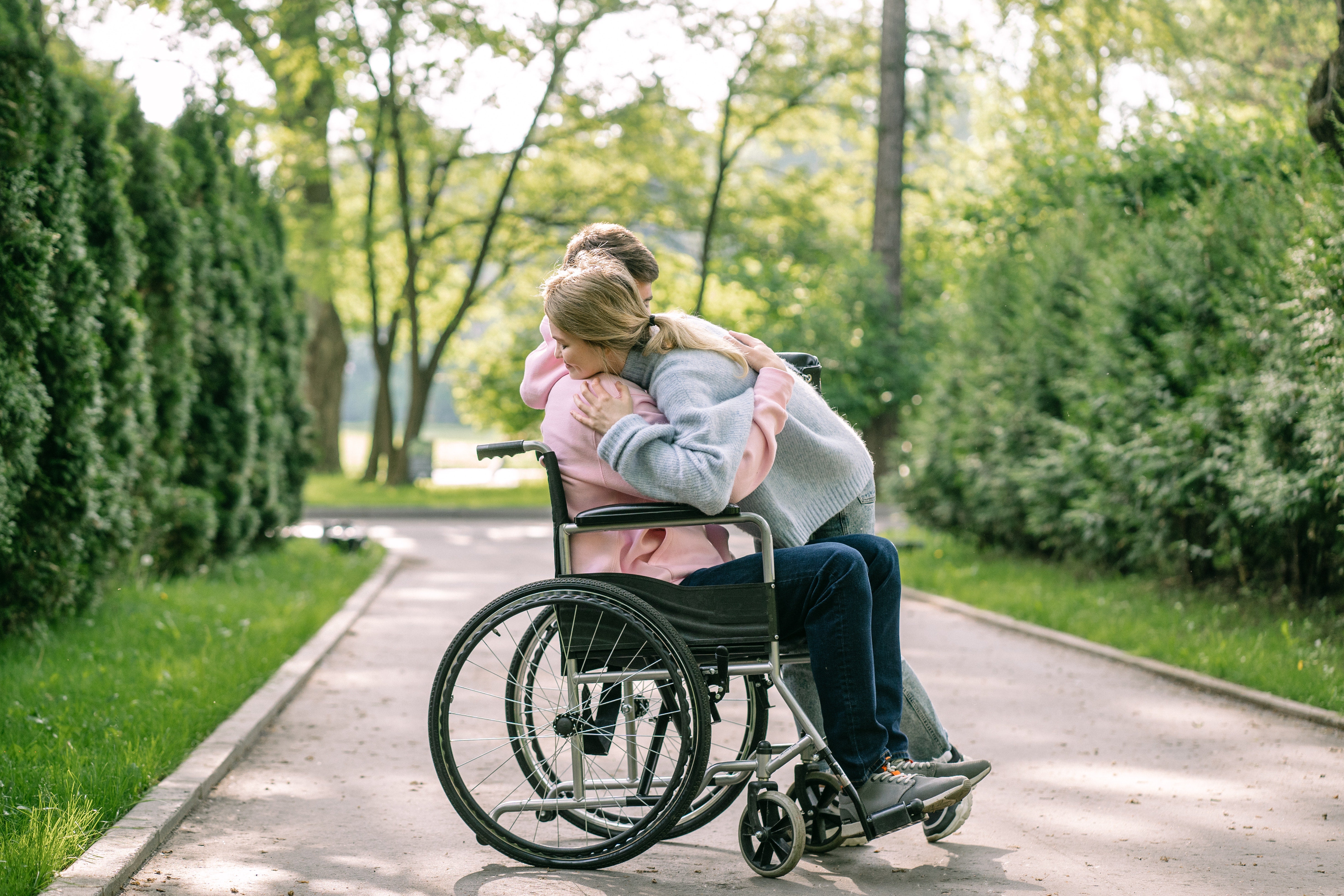 Lady hugging a man in a wheelchair